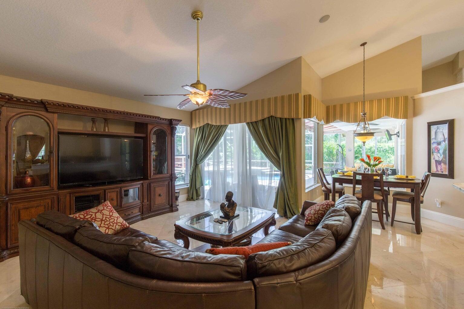 14816 Stirrup Lane Wellington, FL 33414 - Photo 7 of 30 a living room with furniture a flat screen tv and a large window