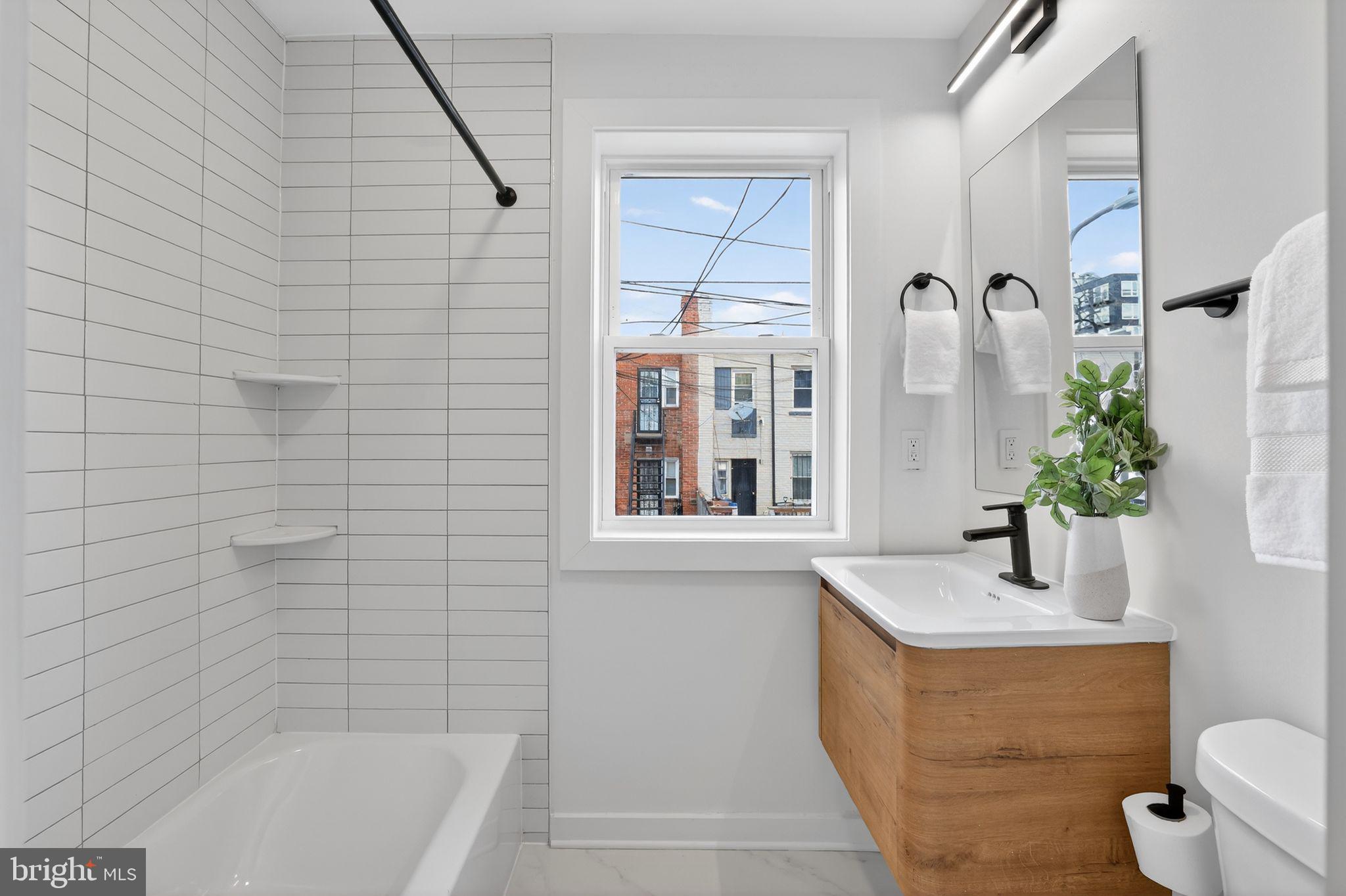 777 18th Street Northeast Washington, DC 20002 - Photo 18 of 22 a bathroom with a granite countertop sink a toilet and shower