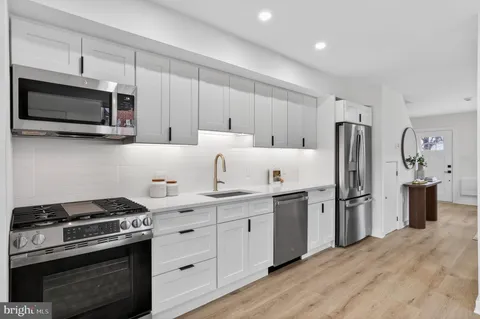 a kitchen with stainless steel appliances a stove microwave and refrigerator