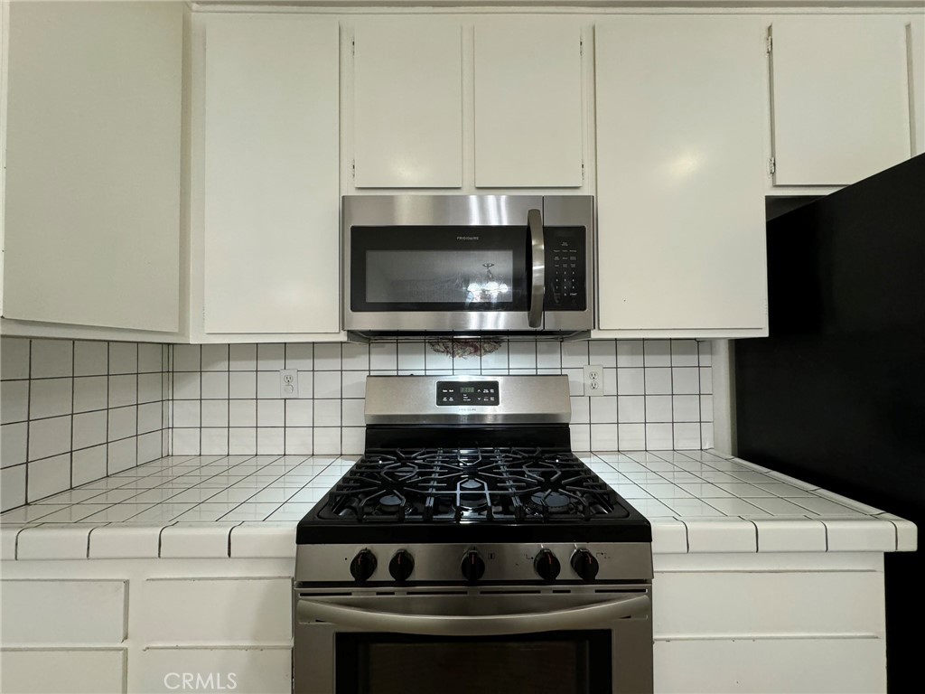 25 Orange Blossom, Unit 61 Irvine, CA 92618 - Photo 4 of 12 a kitchen with microwave a stove and cabinets