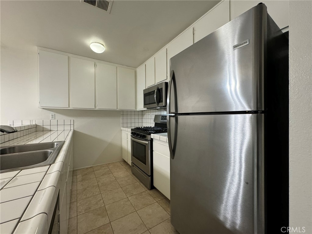 25 Orange Blossom, Unit 61 Irvine, CA 92618 - Photo 5 of 12 a kitchen with a refrigerator stove and sink