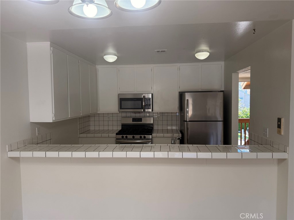 25 Orange Blossom, Unit 61 Irvine, CA 92618 - Photo 6 of 12 a kitchen with stainless steel appliances a sink and a microwave
