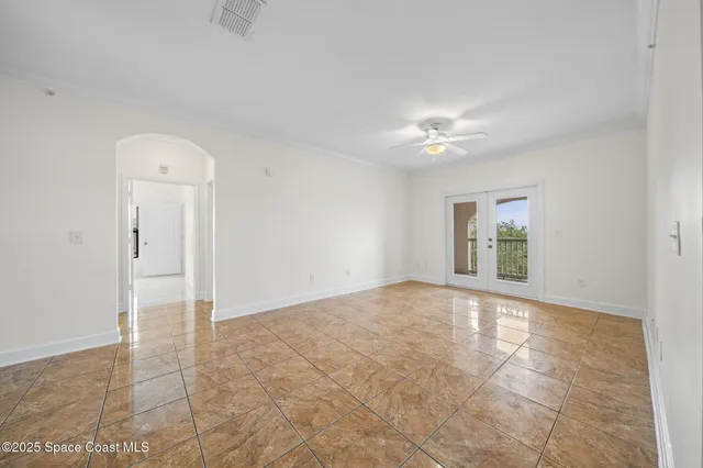 an empty room with a ceiling fan and a window