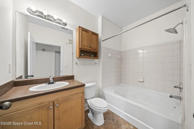 a bathroom with a granite countertop sink a toilet a mirror and shower