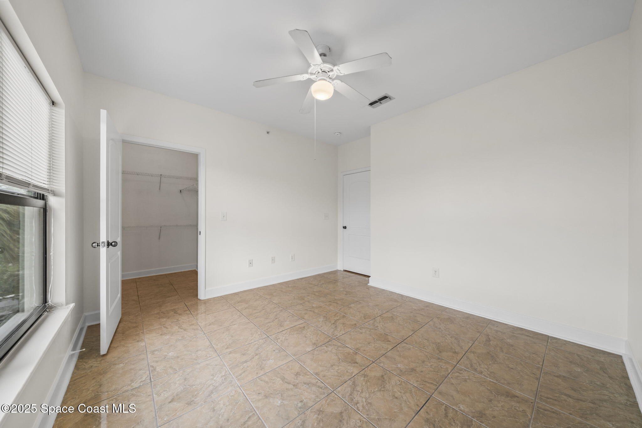 6421 Borasco Drive, Unit 3206 Melbourne, FL 32940 - Photo 23 of 36 an empty room with a ceiling fan and window