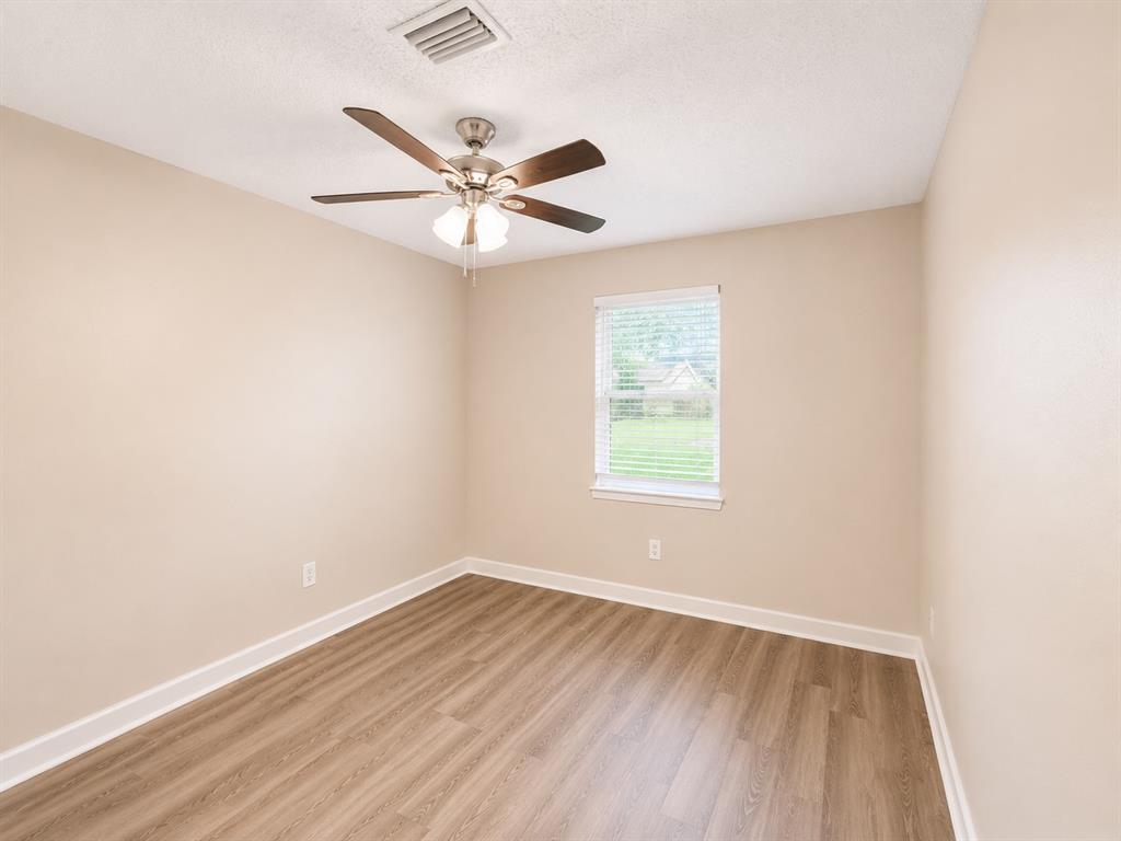 1231 Rutherford Drive Mesquite, TX 75149 - Photo 16 of 29 an empty room with wooden floor fan and windows