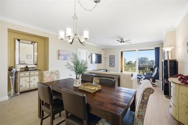 a dining room with wooden floor a chandelier a wooden table and chairs