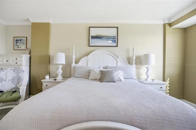 a bedroom with a bed and a painting on the wall