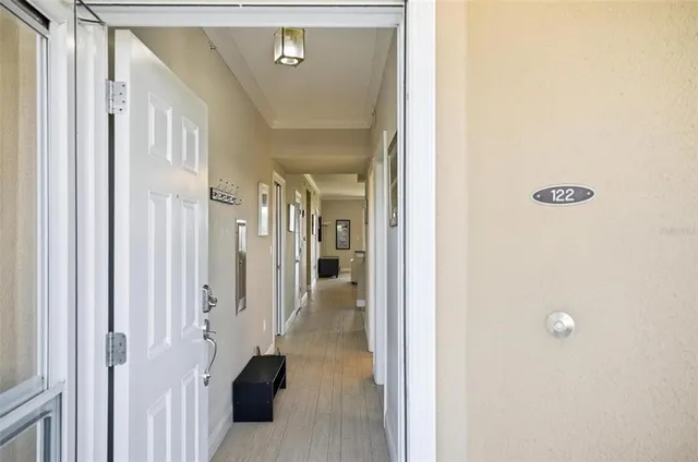 a view of a hallway with wooden floor and staircase