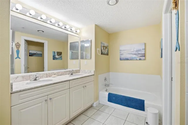 a bathroom with a sink a large mirror and a bathtub