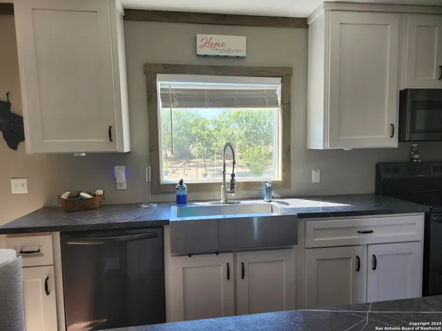 a kitchen with stainless steel appliances granite countertop a sink stove and cabinets
