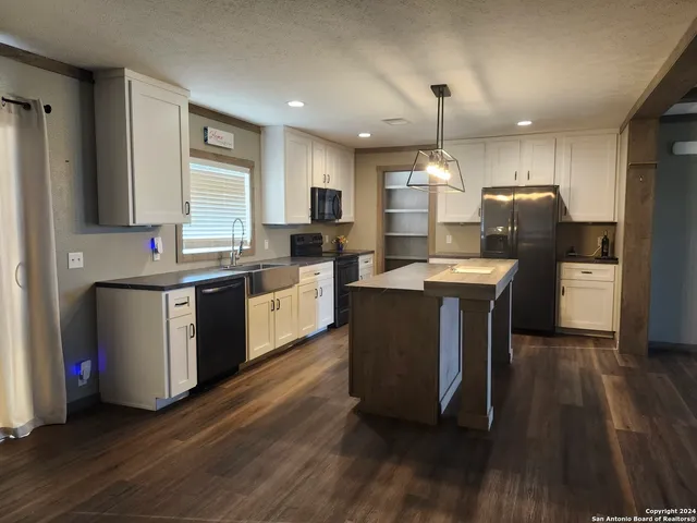 a kitchen with a sink cabinets and wooden floor