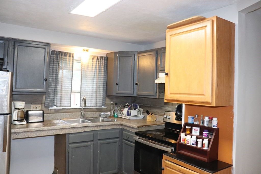 231 Rosewell Street Springfield, MA 01109 - Photo 7 of 24 a kitchen with sink a window and cabinets