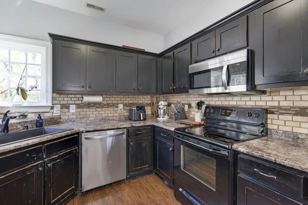 a kitchen with stainless steel appliances a refrigerator stove microwave and cabinets
