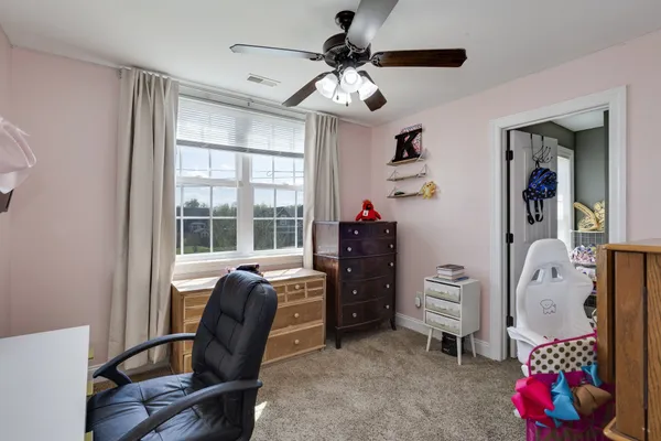 a view of a livingroom with an empty space & a ceiling fan