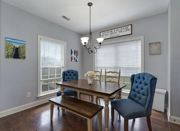 a kitchen with kitchen island granite countertop a stove a sink a refrigerator dining table and chairs
