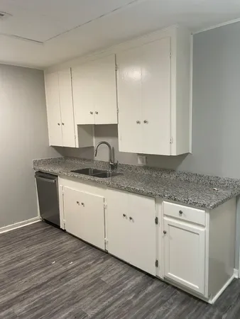 a kitchen with granite countertop white cabinets and a sink
