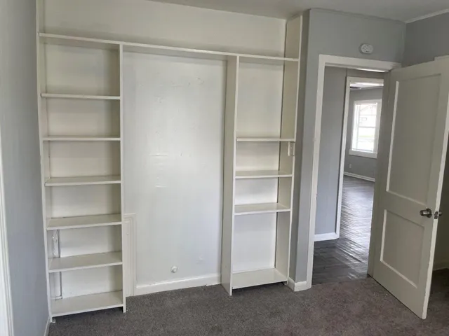 a view of walk in closet with empty racks