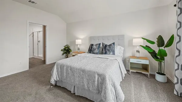 a bedroom with a bed and a potted plant