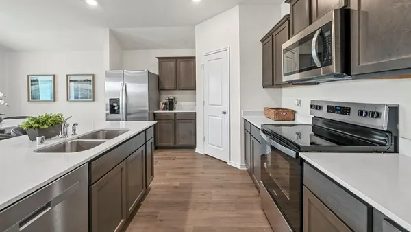 a kitchen with stainless steel appliances granite countertop a sink stove and refrigerator