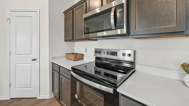 a kitchen with wooden floor and steel stainless steel appliances