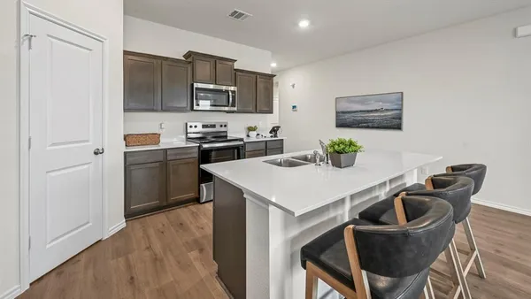 a kitchen with stainless steel appliances a kitchen island a stove a table and chairs