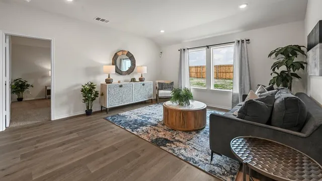 a living room with furniture a rug and a potted plant