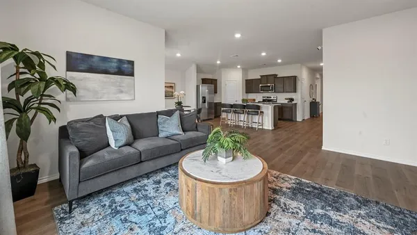 a living room with furniture and a view of kitchen