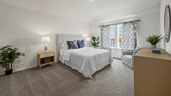 a bedroom with a bed and a potted plant