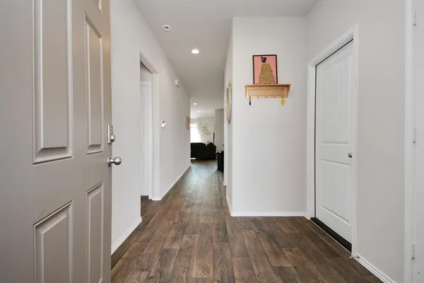 a view of a hallway with wooden floor and closet