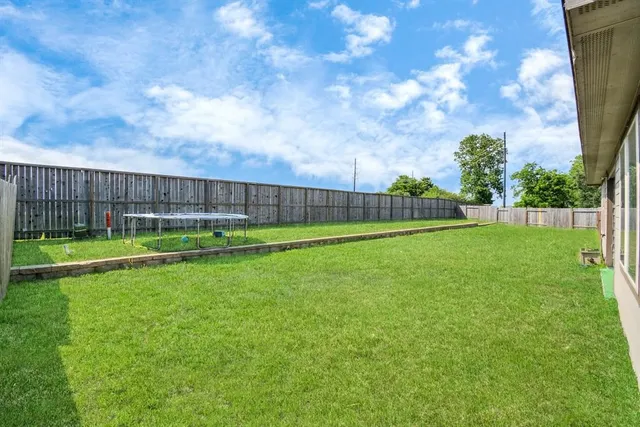 a view of yard with swimming pool and green space