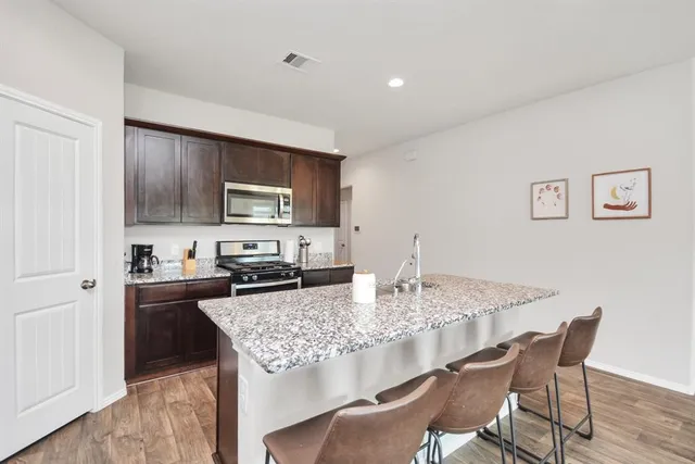 a kitchen with granite countertop kitchen island sink stove and dining table