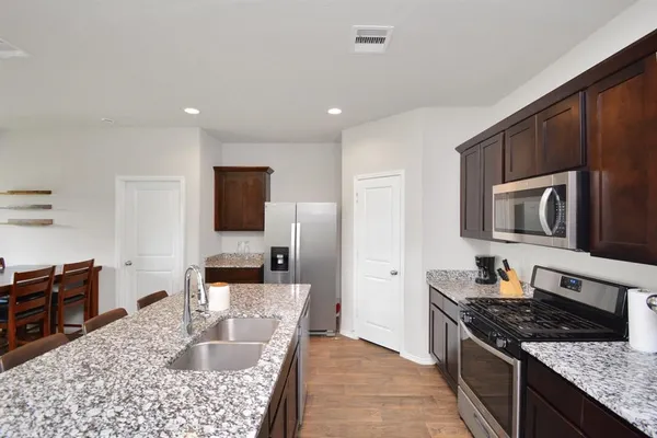 a kitchen with stainless steel appliances granite countertop a sink stove and cabinets
