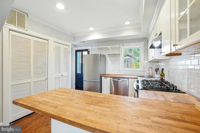 a kitchen with stainless steel appliances kitchen island granite countertop a stove and a refrigerator