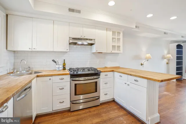 a kitchen with granite countertop white cabinets and white appliances