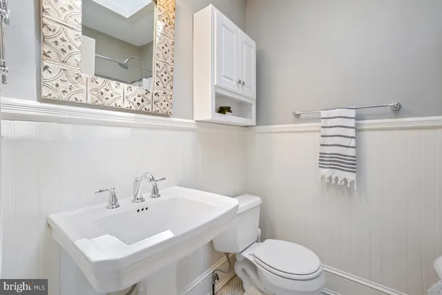 a bathroom with a sink a toilet and mirror