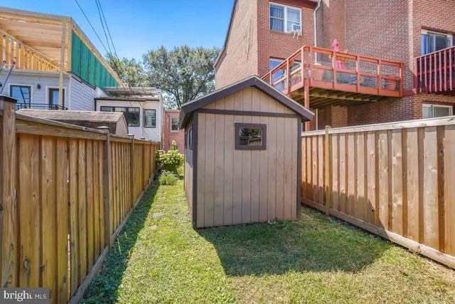 a view of a small yard in front of a house with wooden fence