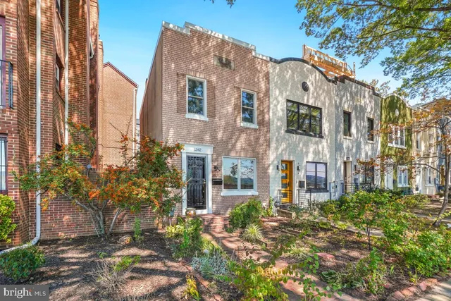 a front view of a multi story residential apartment building with yard