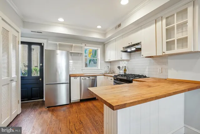 a kitchen with a refrigerator and a stove top oven