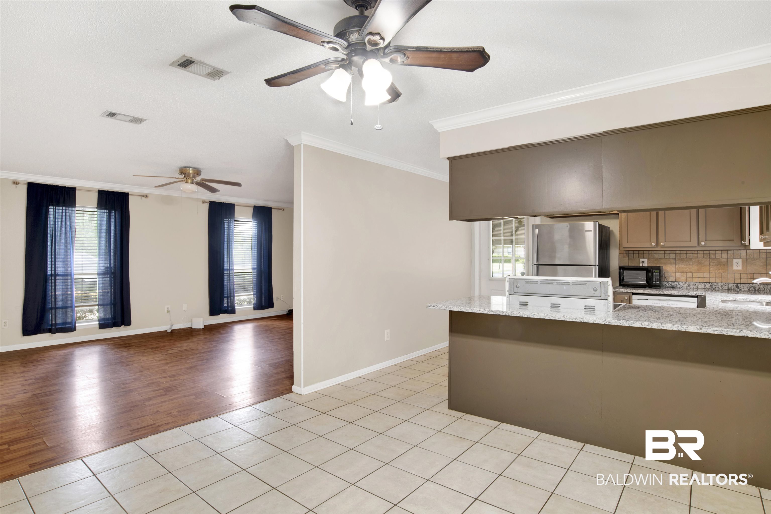 3560 Creekway Road Mobile, AL 36619 - Photo 10 of 24 Kitchen with stainless steel fridge, light tile patterned flooring, ornamental molding, and ceiling fan