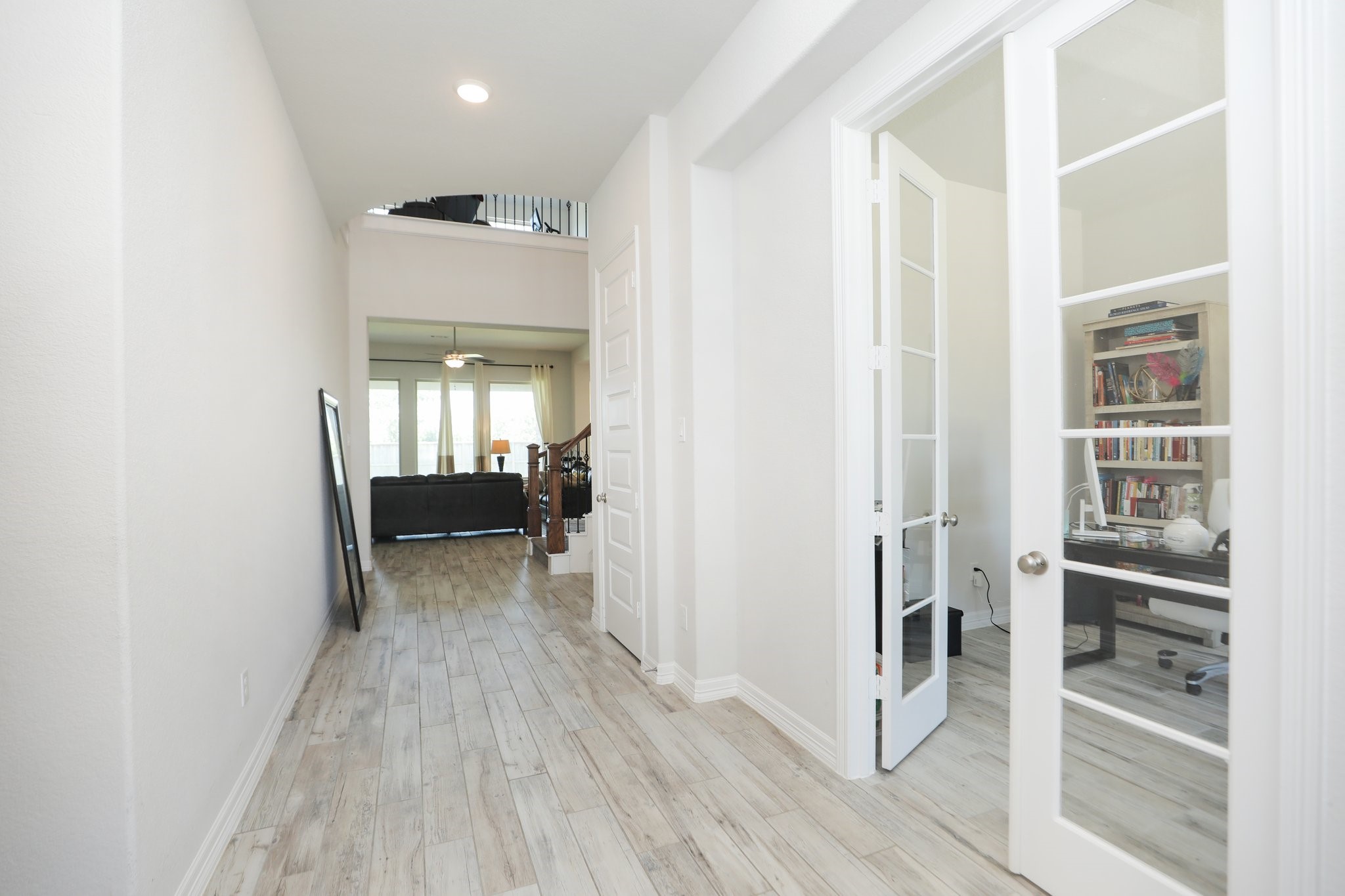 10134 Blythe Street Rosharon, TX 77583 - Photo 6 of 50 a view of a hallway with wooden floor and a living room