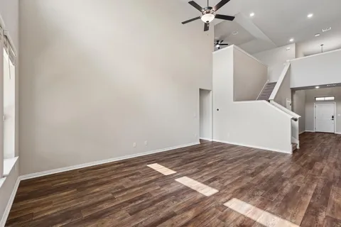 a view of a livingroom with wooden floor and a ceiling fan