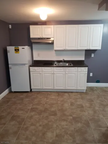 a kitchen with granite countertop a sink a stove and cabinets