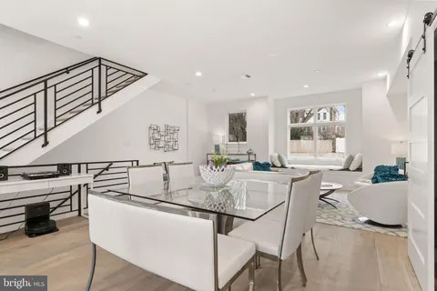 a kitchen with stainless steel appliances kitchen island granite countertop a table and chairs in it
