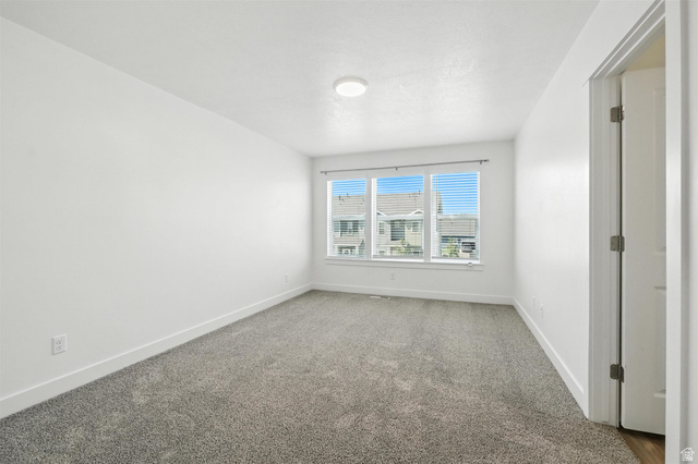 1221 West 1870 South Logan, UT 84321 - Photo 12 of 20 Room featuring light-toned carpeting, white walls, and a multi-pane window with blinds