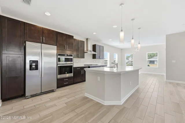 a kitchen with stainless steel appliances granite countertop a sink stove and refrigerator
