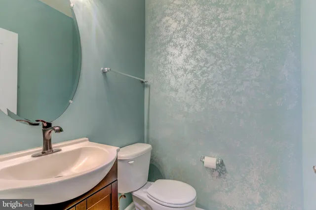 a bathroom with a sink a toilet and mirror