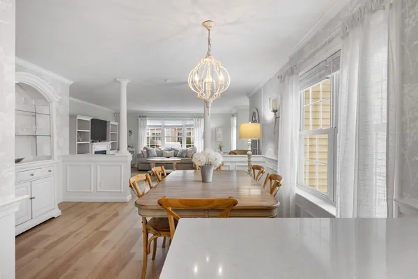 a view of a dining room with furniture a chandelier and wooden floor