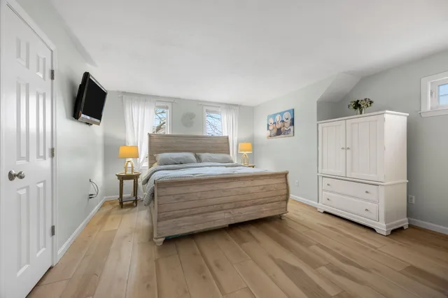 a bedroom with a bed and a flat tv screen on the dresser