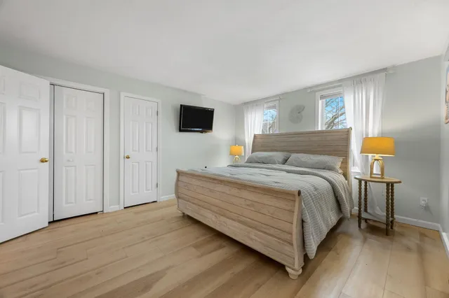 a bedroom with a bed and wooden floor